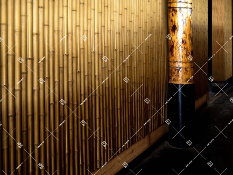 Parede de destaque em painéis de ripas de bambu sintético com uma coluna iluminada