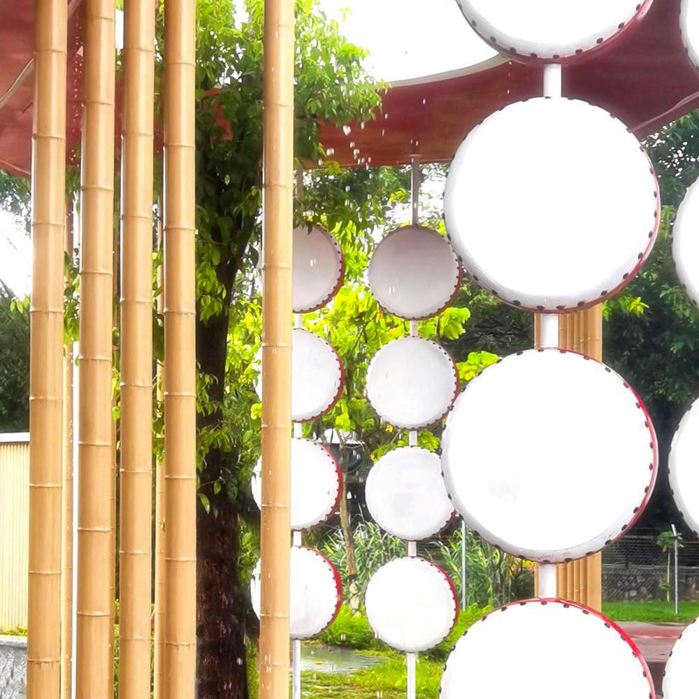 Aluminum bamboo poles beside a display of red-and-white drums outdoors
